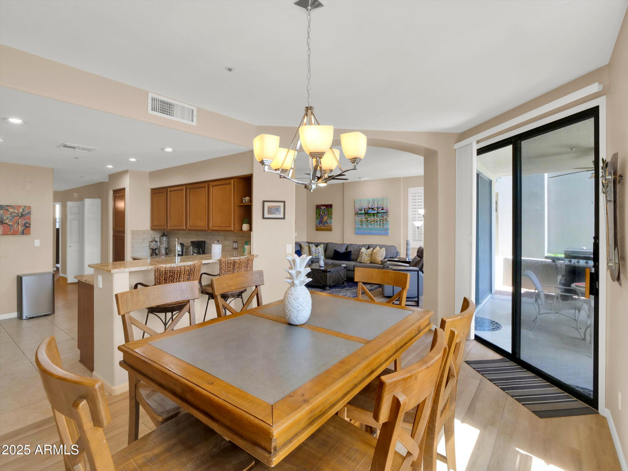 7700 East Gainey Ranch Road, Unit 120 Scottsdale, AZ 85258 - Photo 12 of 57 a room with stainless steel appliances a dining table and chairs