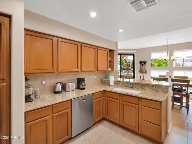 a kitchen with stainless steel appliances granite countertop refrigerator sink and microwave