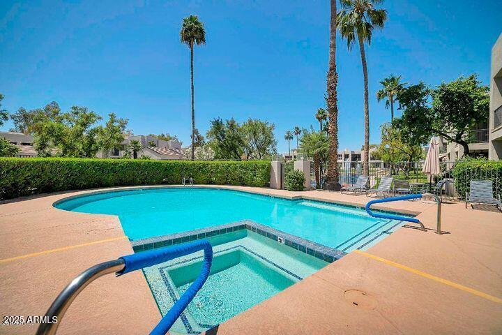 7700 East Gainey Ranch Road, Unit 120 Scottsdale, AZ 85258 - Photo 47 of 57 a view of a swimming pool with a bench and trees
