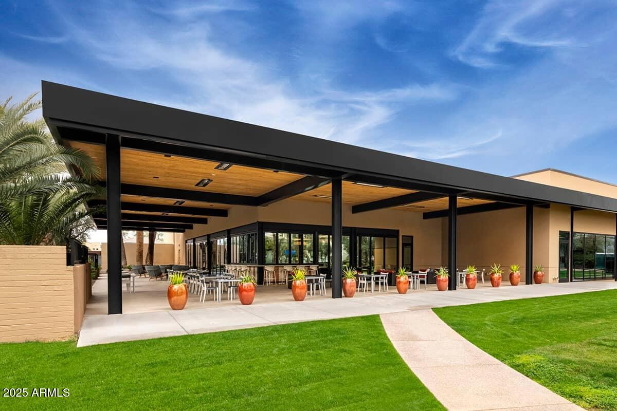 7700 East Gainey Ranch Road, Unit 120 Scottsdale, AZ 85258 - Photo 56 of 57 a view of a patio with table and chairs under an umbrella
