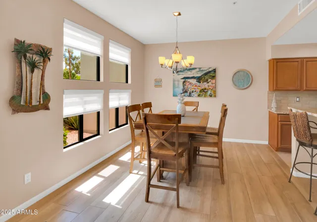 a view of a dining room with furniture a chandelier a kitchen and chandelier