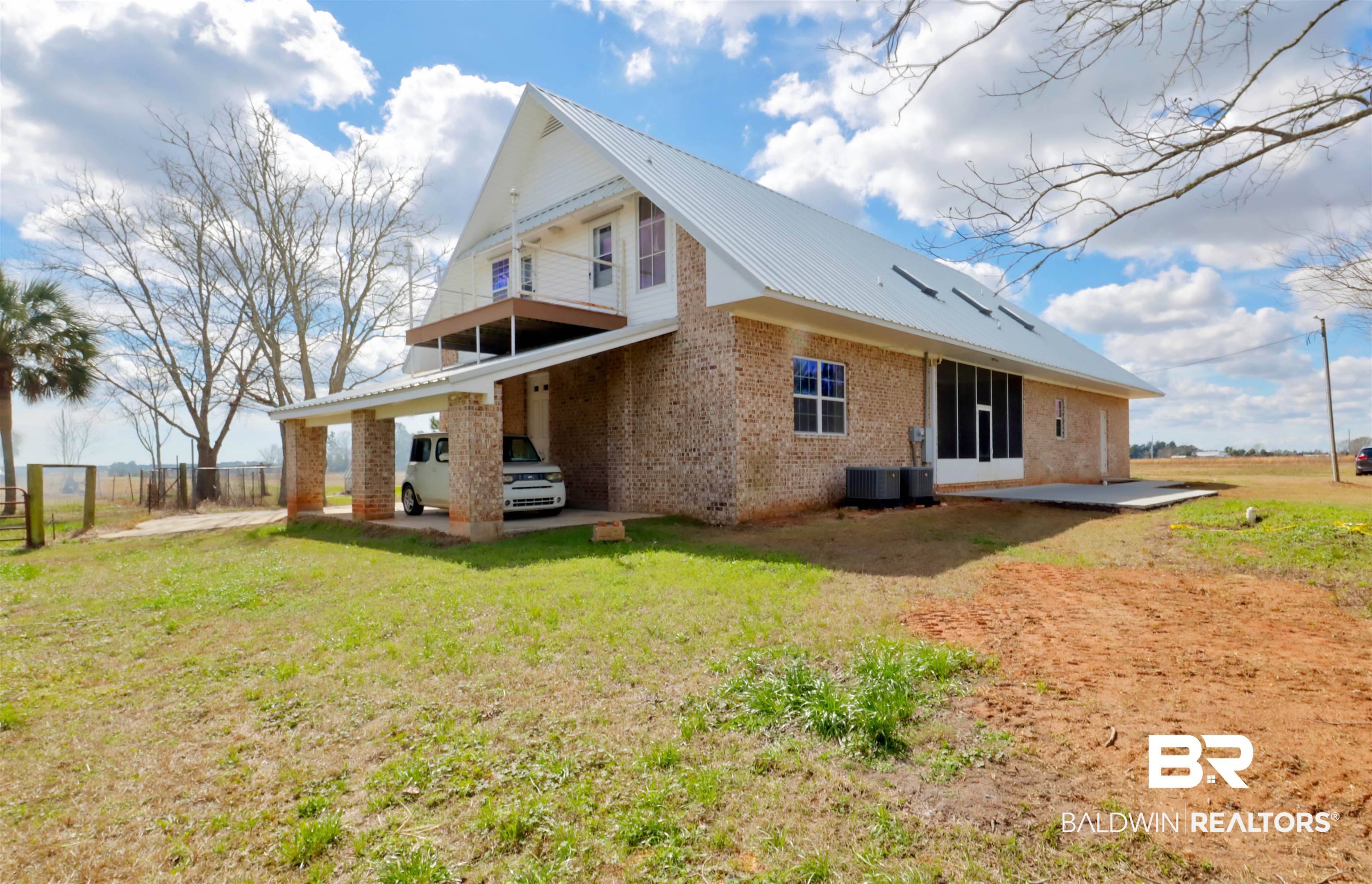 28461 Gardner Road Elberta, AL 36530 - Photo 35 of 46 Rear view of house with a patio area, brick siding, a metal roof, and a balcony