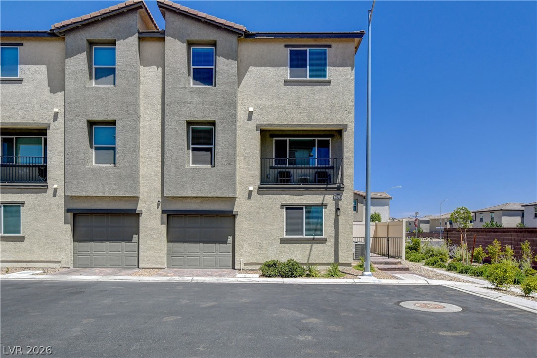 Modern townhome exterior with attached garages and a private balcony for urban living.