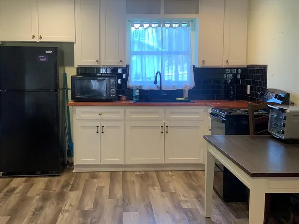 a kitchen with stainless steel appliances granite countertop a refrigerator a stove a sink and a microwave