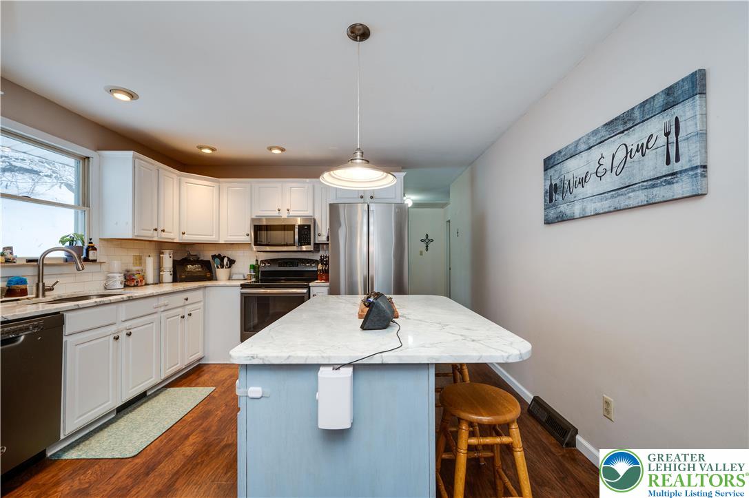 6838 Lime Kiln Road Slatington, PA 18080 - Photo 20 of 60 a kitchen with stainless steel appliances a kitchen island a stove a table and chairs in it