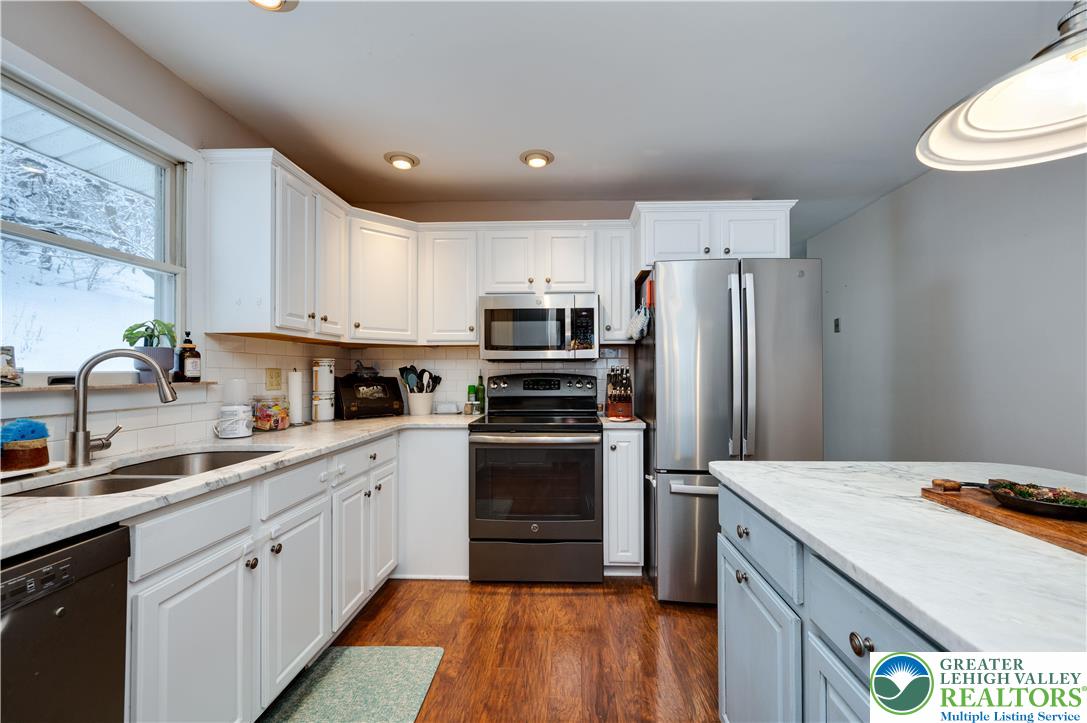 6838 Lime Kiln Road Slatington, PA 18080 - Photo 21 of 60 a kitchen with a sink a refrigerator a microwave and cabinets