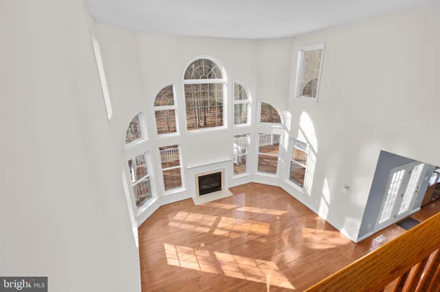 a view of a livingroom with furniture wooden floor chandelier and a window