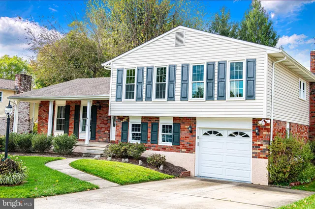 a front view of a house with a yard and potted plants