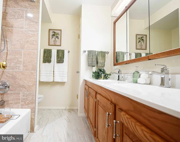 a spacious bathroom with a double vanity sink a mirror and a bathtub