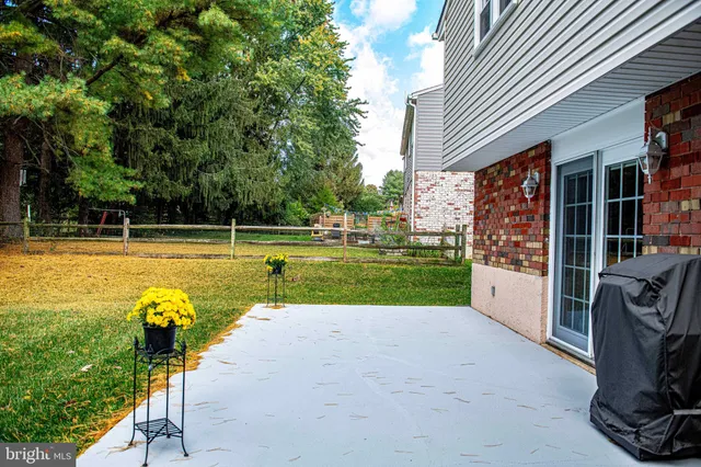 a view of swimming pool with seating area and trees in the background