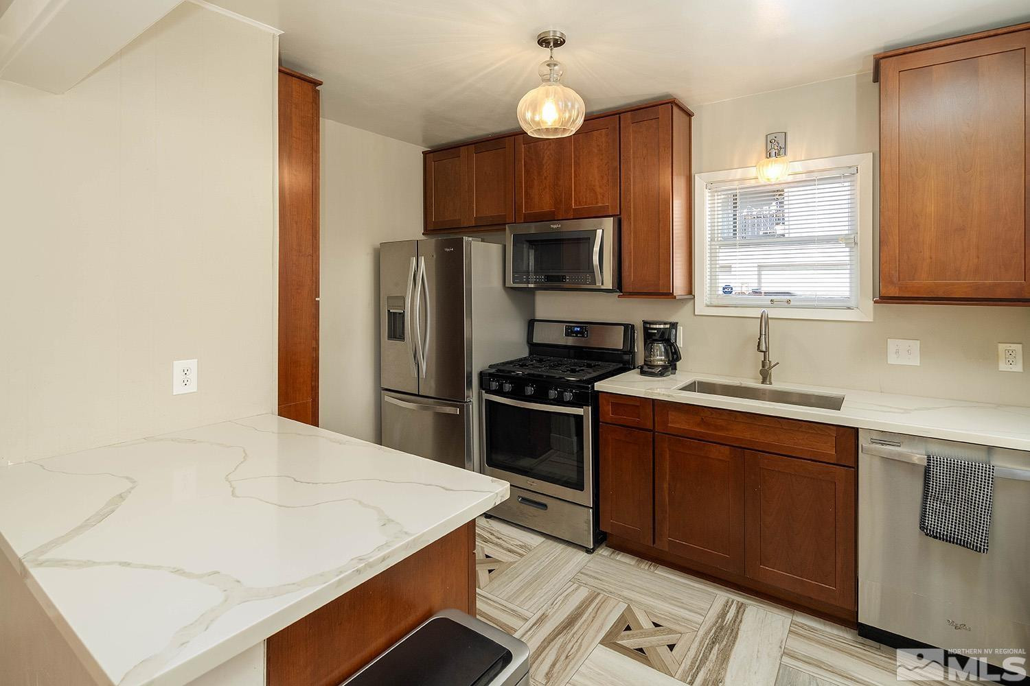 207 Martin Street Reno, NV 89509 - Photo 9 of 40 a kitchen with stainless steel appliances a sink a stove a refrigerator cabinets and a center island