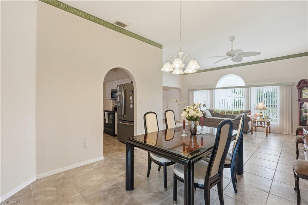25378 Rupert Road Punta Gorda, FL 33983 - Photo 10 of 50 Tile flooring throughout, featuring an arched doorway, white chandelier, and vaulted ceilings