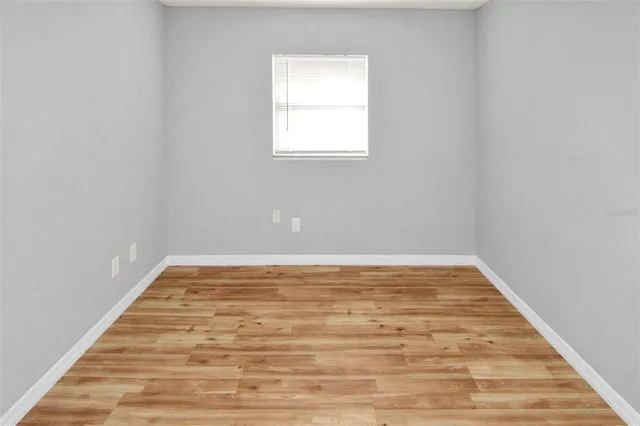 a view of empty room with wooden floor