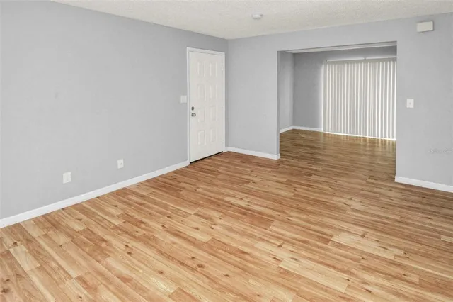 a view of empty room with wooden floor