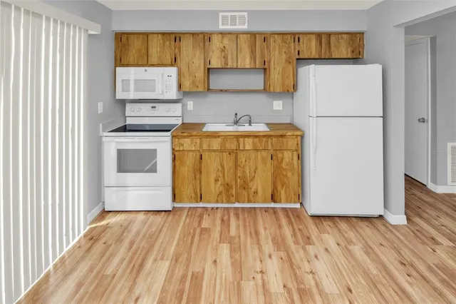 a utility room with wooden floor washer and dryer