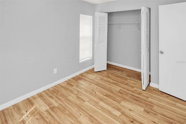 an empty room with wooden floor and closet