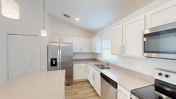 a kitchen with a refrigerator stove and microwave