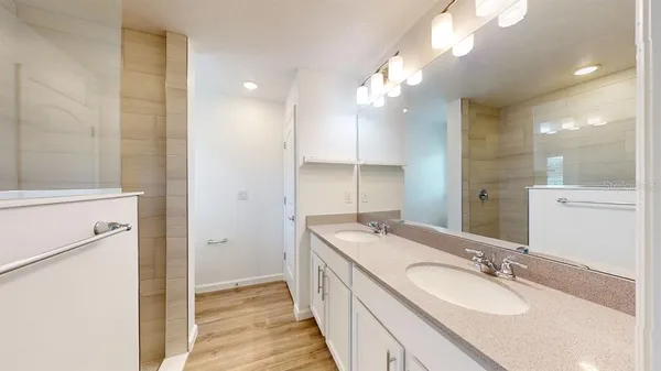 a bathroom with a double vanity sink a mirror and a shower