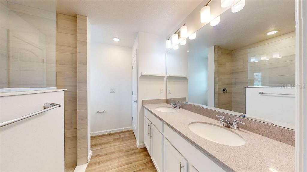 6089 Deer Run Road North Port, FL 34291 - Photo 7 of 10 a bathroom with a double vanity sink a mirror and a shower