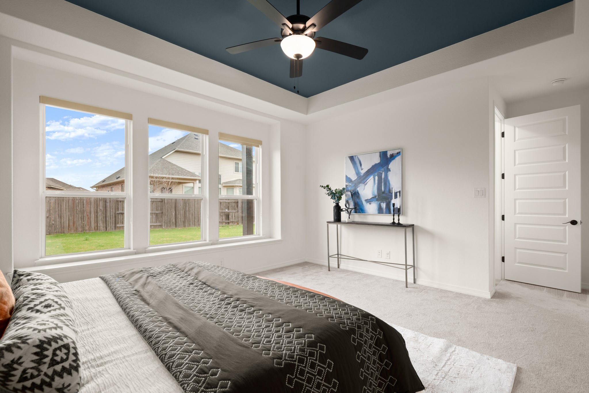 20521 Martin Lane Pflugerville, TX 78660 - Photo 14 of 40 Enjoy the peace and tranquility of a secluded main floor primary suite with generouos windows overlooking the backyard and elegant tray ceilings.