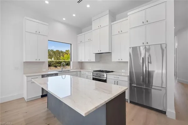 a large kitchen with cabinets wooden floor and stainless steel appliances