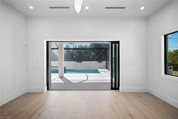 an empty room with glass door and shower