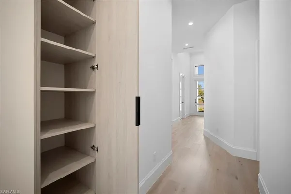 a view of a hallway with wooden floor and staircase