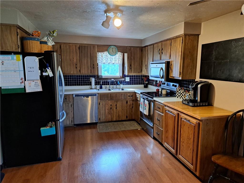 5146 McCandless Road Butler, PA 16001 - Photo 8 of 24 a kitchen with stainless steel appliances a sink cabinets and wooden floor