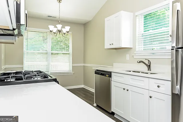 a kitchen with stainless steel appliances granite countertop a sink stove and cabinets