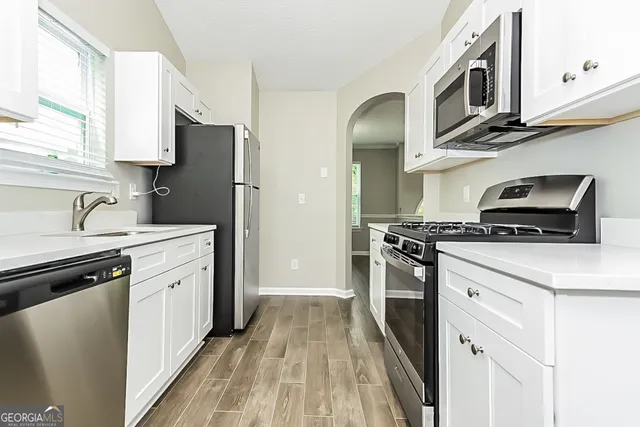a kitchen with stainless steel appliances a stove microwave and a sink