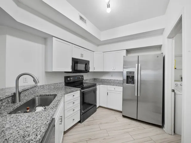 a kitchen with stainless steel appliances granite countertop a sink stove and refrigerator