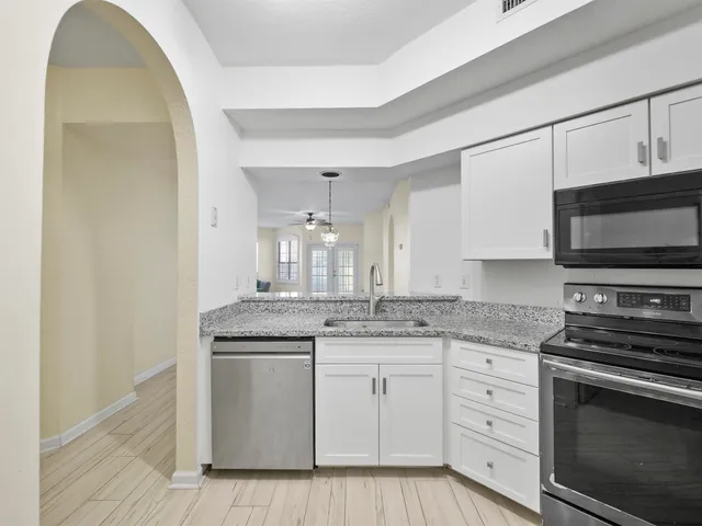 a kitchen with stainless steel appliances granite countertop a stove a sink and a microwave