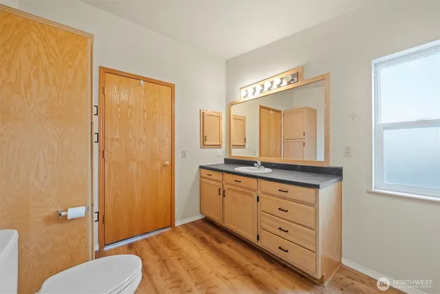 a bathroom with a granite countertop sink toilet and mirror