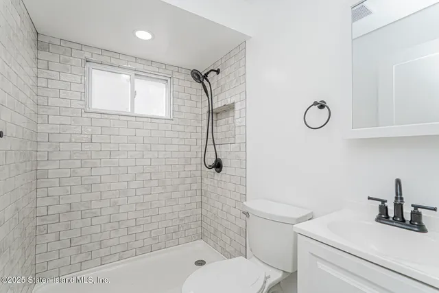 a bathroom with a shower a toilet and a sink