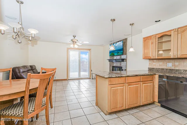 a kitchen with stainless steel appliances granite countertop a sink a stove a dining table and chairs with wooden floor