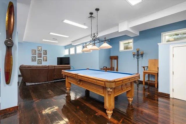 a room with pool table windows and wooden floor