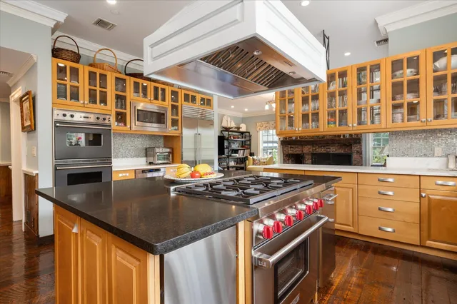 a kitchen with stainless steel appliances granite countertop a stove a sink and a microwave