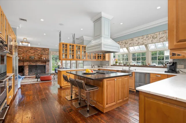 a kitchen with stainless steel appliances granite countertop a table and chairs
