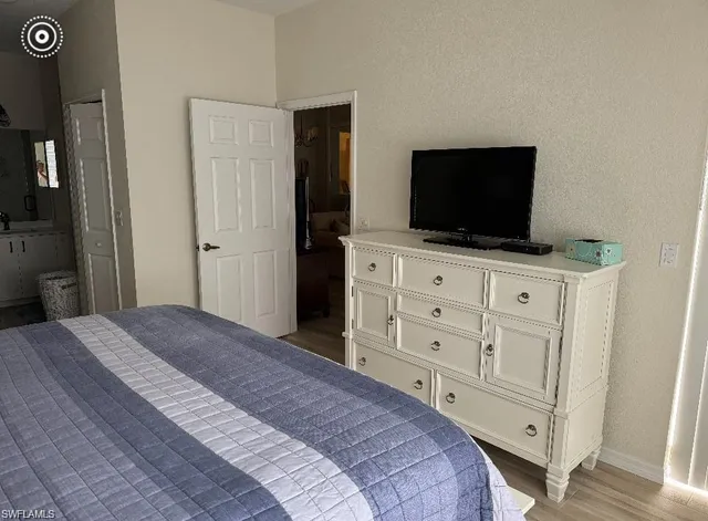a bedroom with a bed and a flat screen tv in it