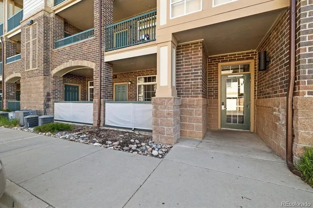 a view of an empty room with kitchen and a fireplace