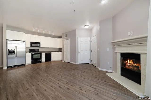 a kitchen with stainless steel appliances kitchen island granite countertop a refrigerator and a sink