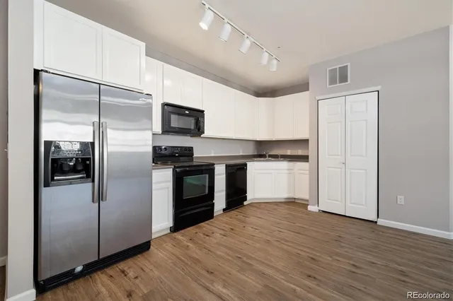 a kitchen with wooden floors and appliances