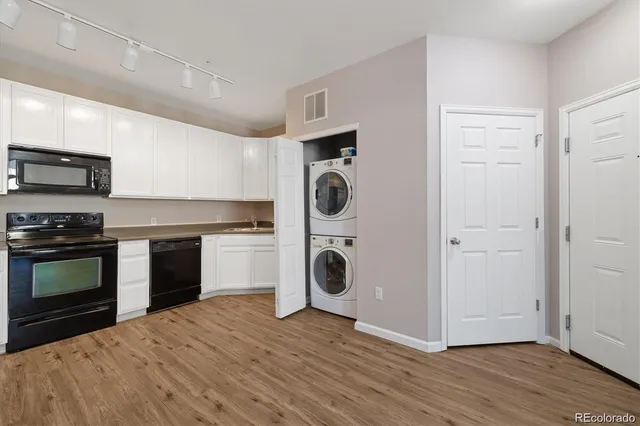 a view of a kitchen with wooden floor and electronic appliances