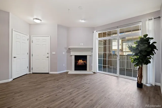 a view of an empty room with glass door and wooden floor