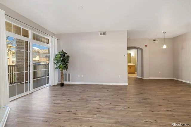 an empty room with wooden floor and fireplace