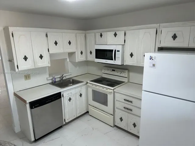 a kitchen with cabinets appliances and a sink