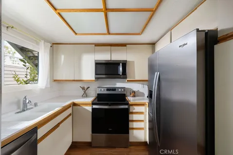 a kitchen with stainless steel appliances a refrigerator a sink a stove and microwave