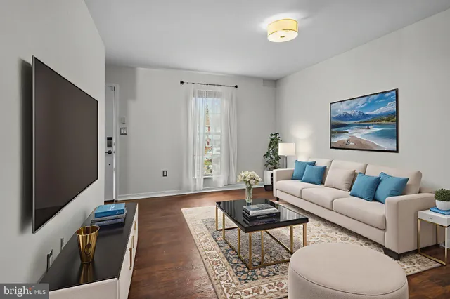 a living room with furniture a rug and a flat screen tv