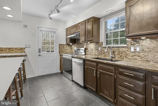 a kitchen with a stove a sink and a refrigerator