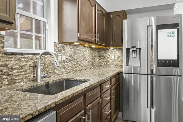 a kitchen with stainless steel appliances granite countertop a refrigerator and a sink
